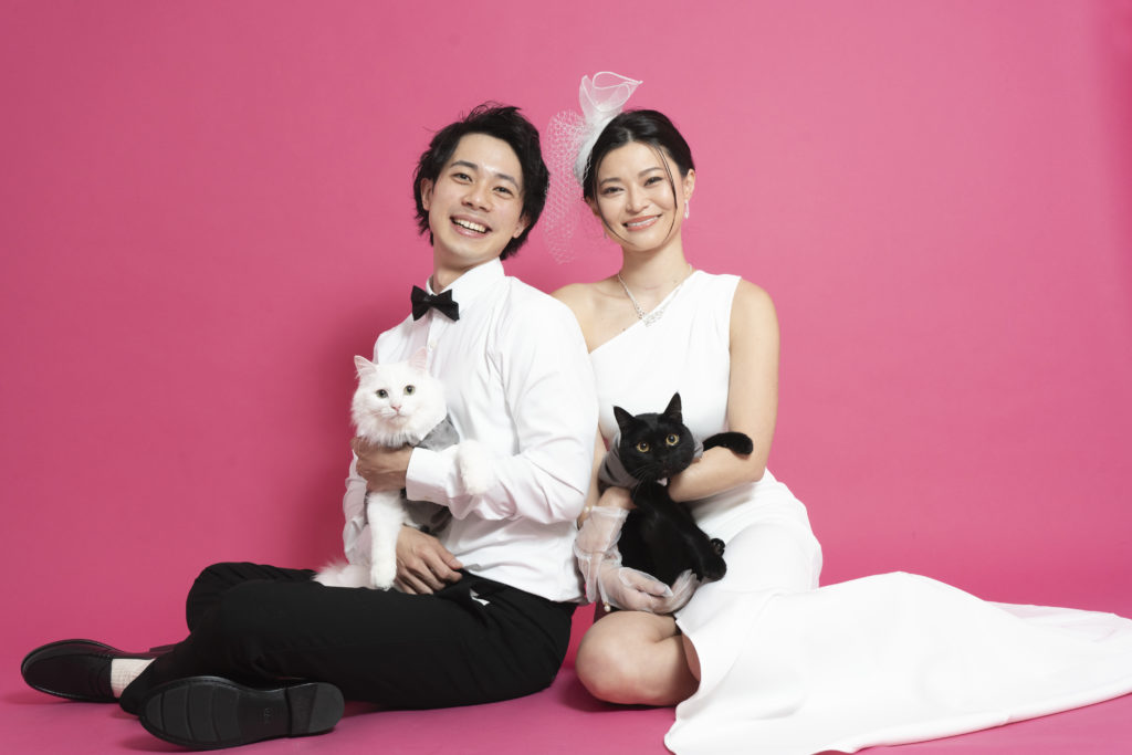 新郎新婦が猫を抱いて座っている