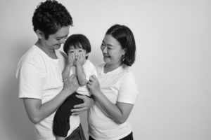 お父さんとお母さんが子供を抱いているモノクロ写真