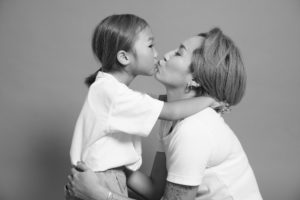お母さんが子供にキスをしているモノクロ写真