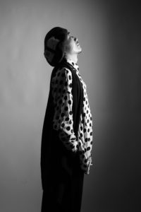 男性が横を向いてポーズをつけているモノクロ写真