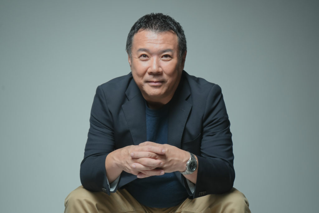 男性が手を組み座っている