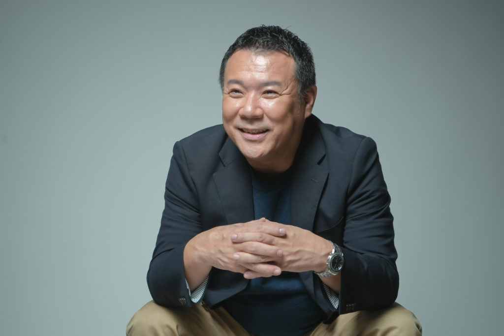 男性が手を組み座っている