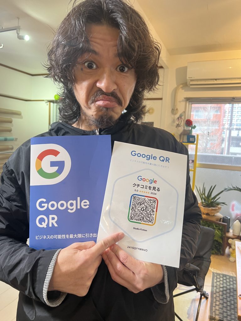 Googleの口コミステッカーを持つ男性