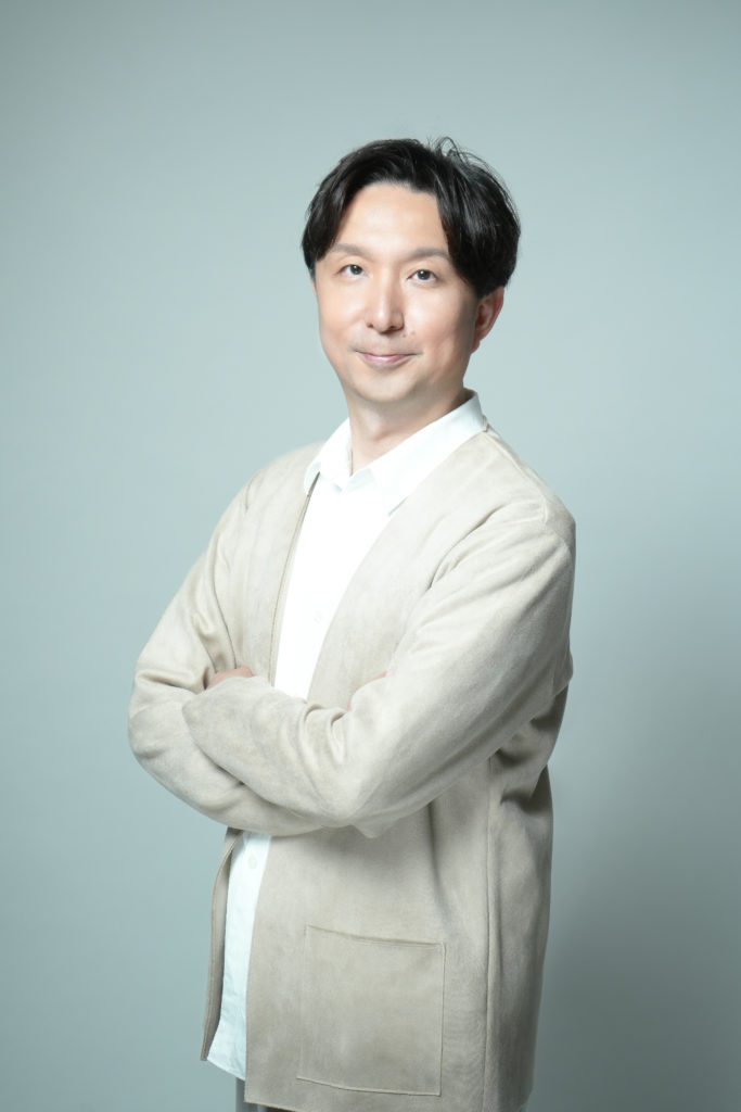 男性が腕を組み笑顔の写真