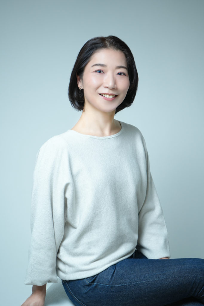 女性が笑顔で座っている写真