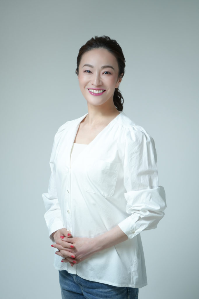 白いシャツを着た笑顔の女性の写真
