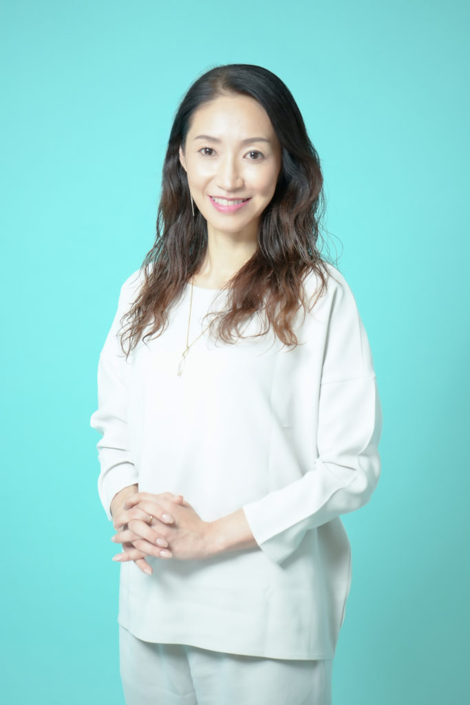 白いシャツを着て笑顔の女性の写真