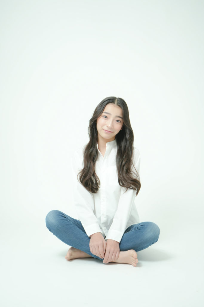白いシャツにデニムを履いた少女
