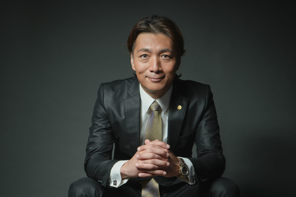 スーツで手を組んでいる男性の写真
