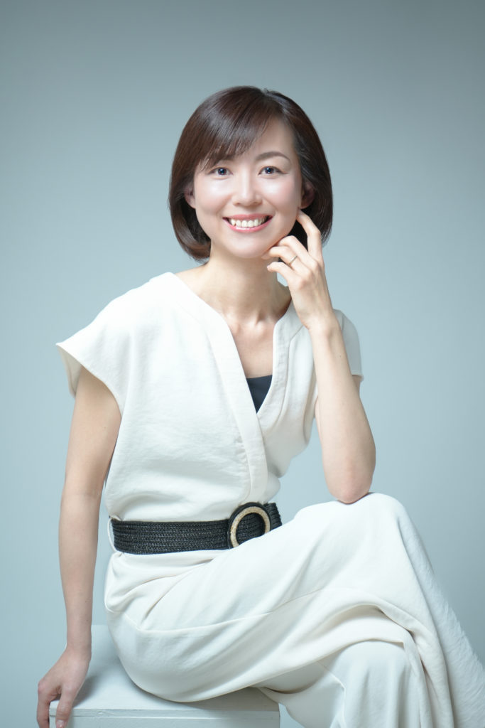 白の服を着てポーズを取る女性の写真