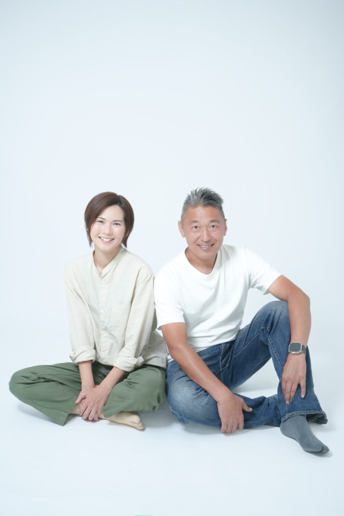 床に座って自然な表情をする夫婦写真