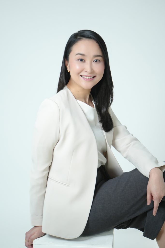 スーツを着た女性がポージングをし座っている写真