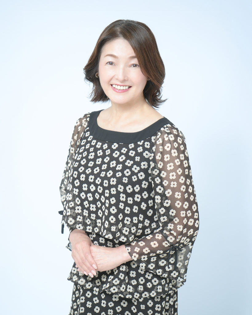 「アサデス。」メインパーソナリティーの徳永玲子さんが立って笑っている写真