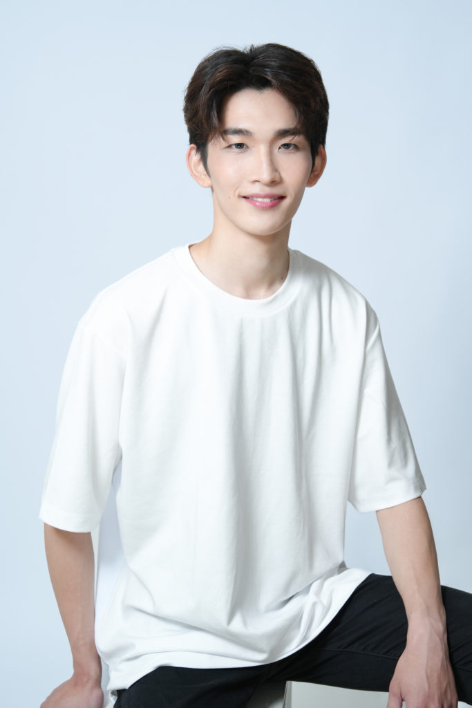 白のTシャツを着て笑顔の男性