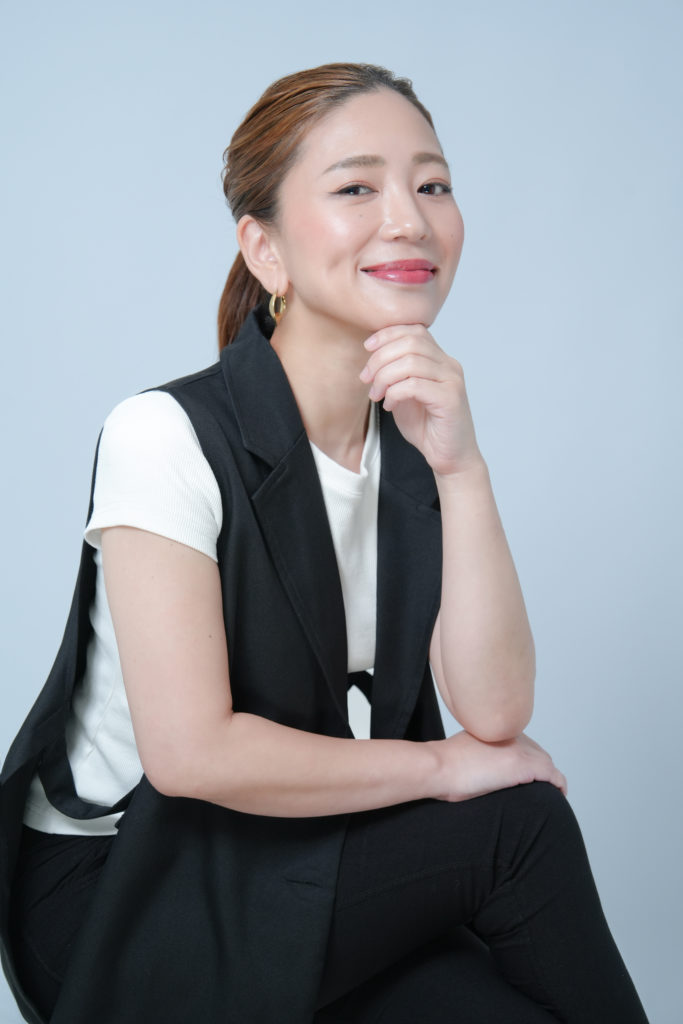 顎に手をかけて微笑む女性の写真