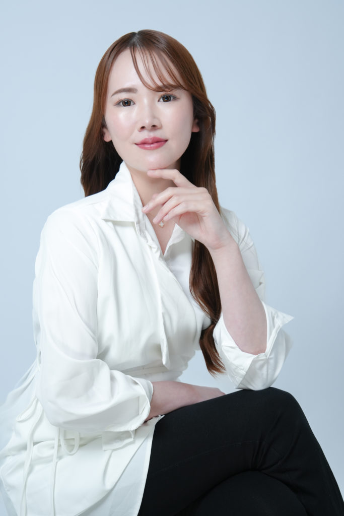 女性が顎に手を当てて座っている