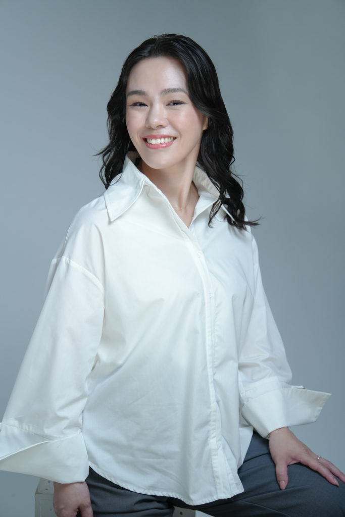 白いシャツを着た笑顔の女性の写真