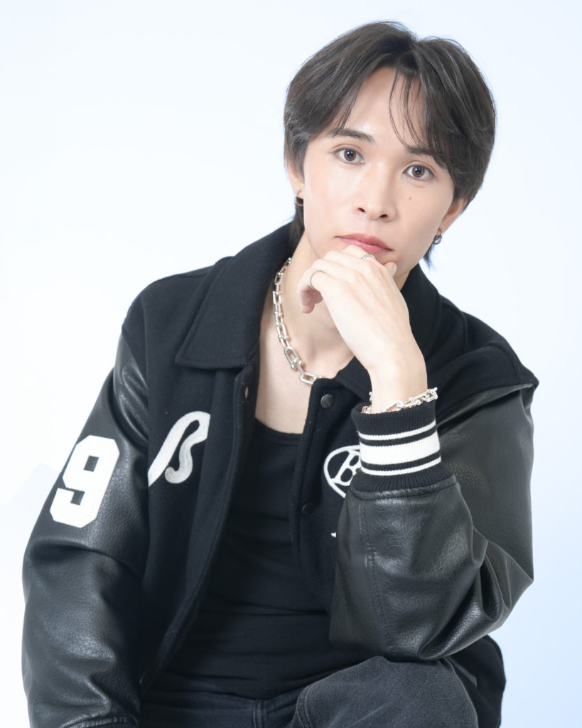 Studio Fictionで撮影した、白色背景で黒色のスタジャンを着た男性のポートレート写真