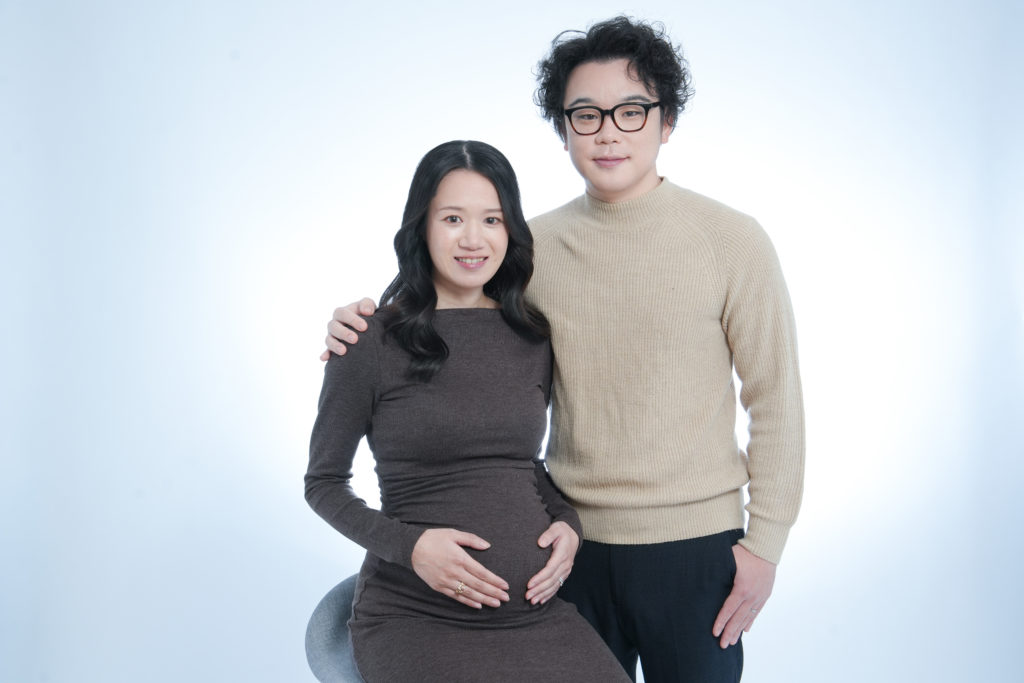 Studio Fictionで撮影した、白背景の女性がマタニティの夫婦写真