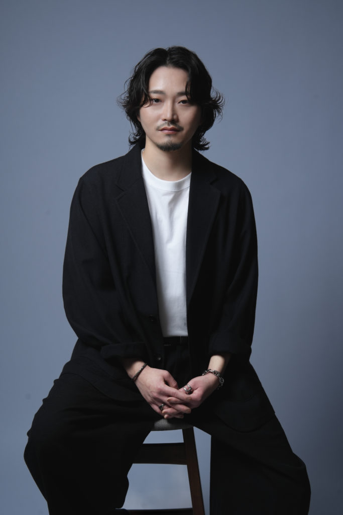 Studio Fictionで撮影した、グレー背景で男性が椅子に座っているポートレート写真
