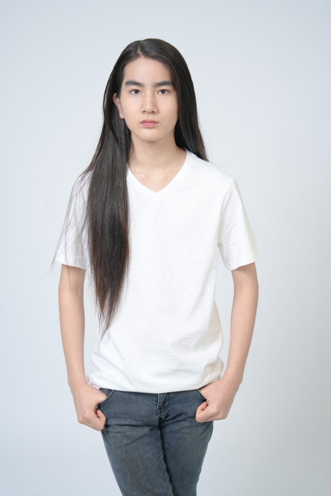 Studio Fictionで撮影した、白色背景で立つ髪の長い男性のポートレート写真