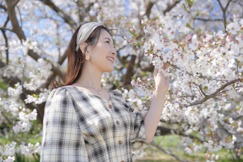女性が桜の前に立っている