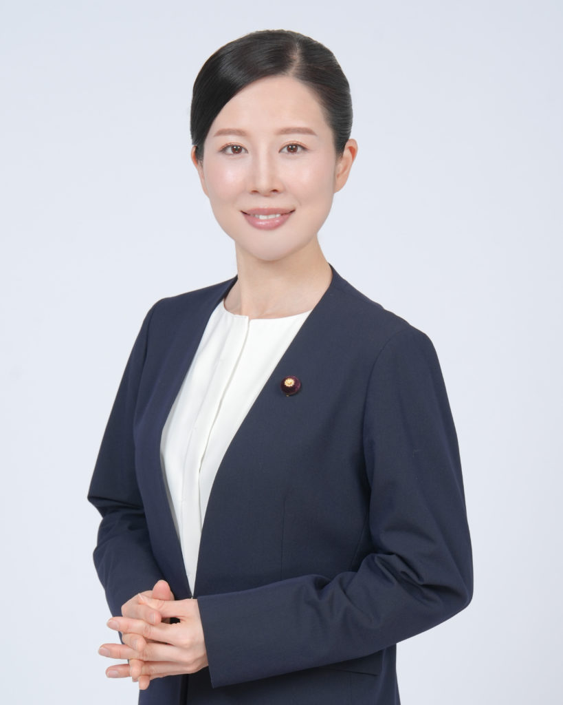 Studio Fictionで撮影した、紺色のジャケットを着て笑顔の女性のポートレート写真