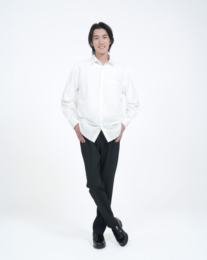 Studio Fictionで撮影した、白のシャツを着た笑顔の男性の全身ポートレート写真