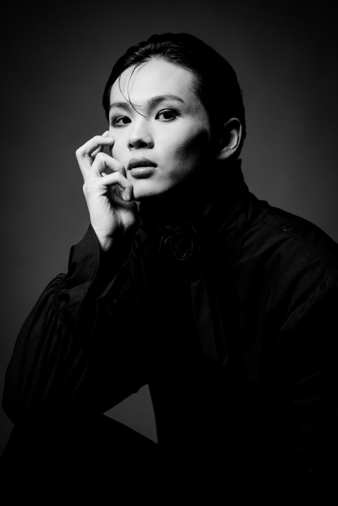 Studio Fictionで撮影した、黒のシャツを着てメイクをした男性のポートレート写真