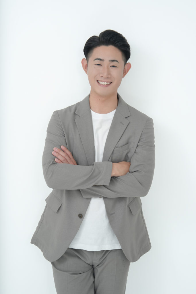 男性が腕を組んで微笑んでいる