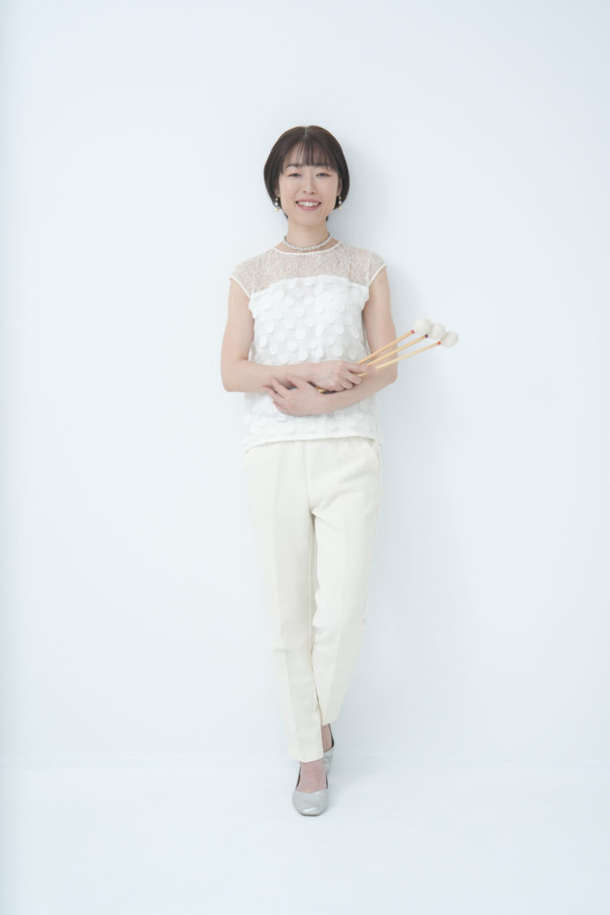 白色の服を纏ってマリンバのマレットを持っている写真