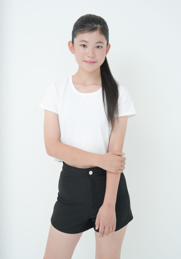 白のTシャツと黒のショートパンツを着た女性の写真